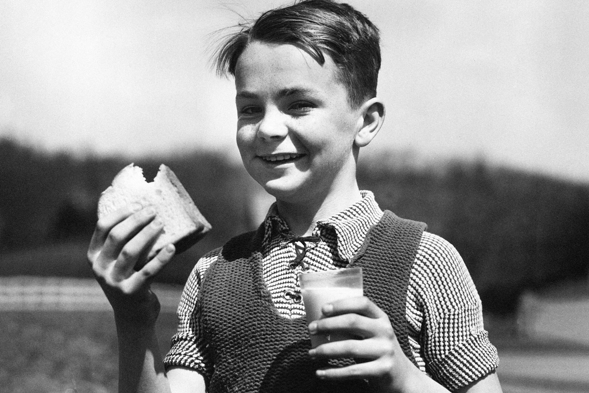Boy eating a sandwich, 1940s